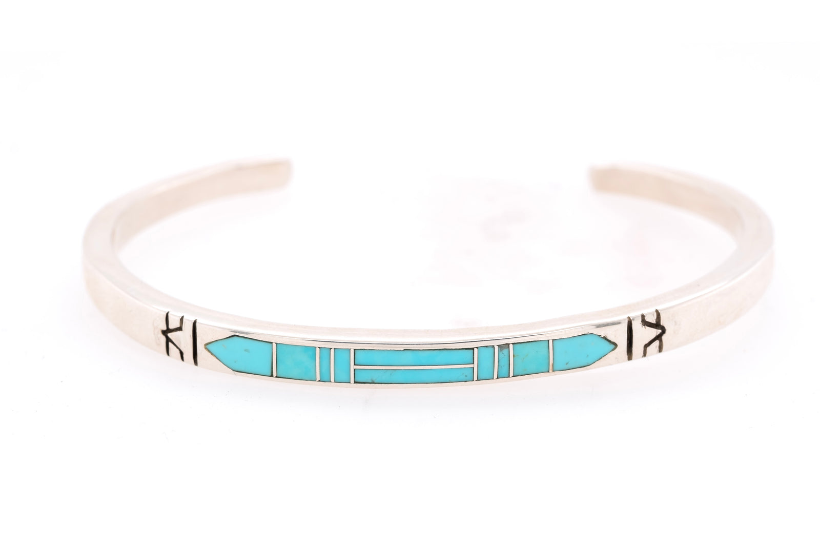 A silver cuff bracelet featuring a turquoise inlay geometric pattern, photographed on a clean white background.