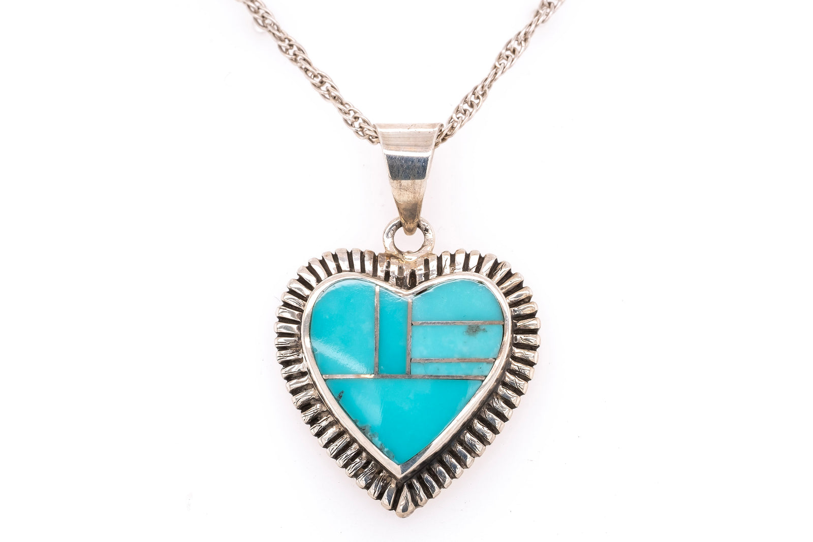 Sterling silver heart pendant with turquoise inlay on a white background.
