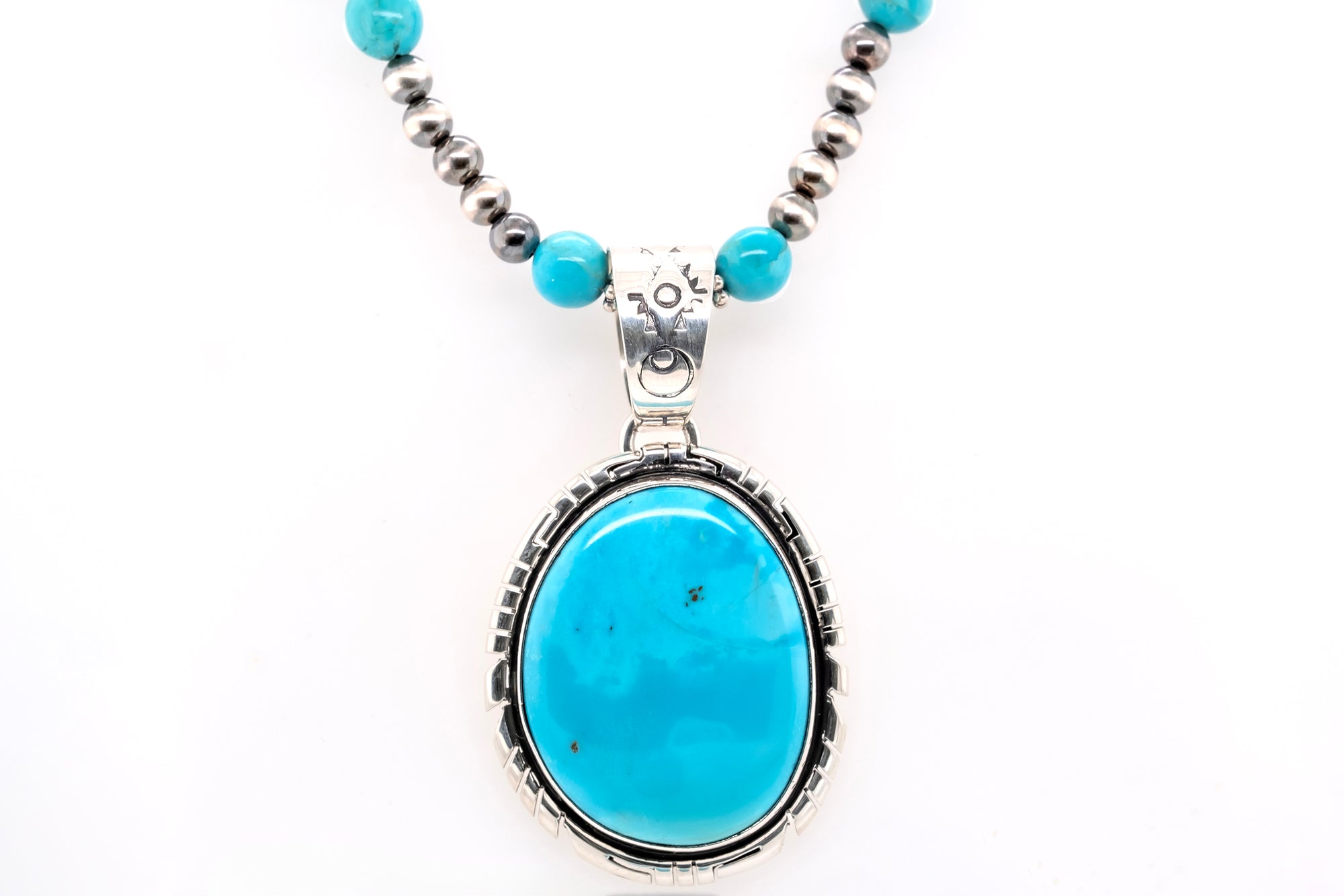 Turquoise pendant necklace with silver and blue beads on a white background