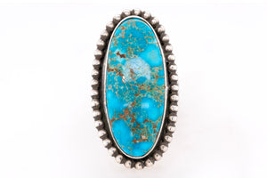 Turquoise stone ring with silver band on a white background